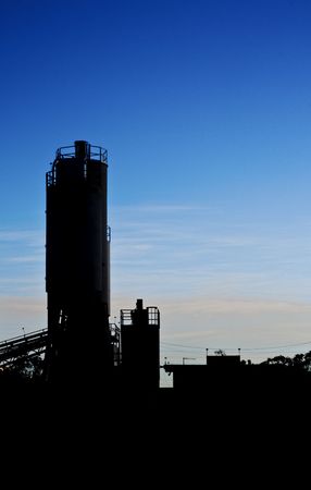 Silhouette of an industrial plant with silo and buildingsの写真素材