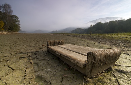 A lake  dries up during a drought. Focus on the trash. Litter and trash exposed after a lake dries.の写真素材
