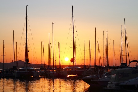 Marina with docked yachts at the sunsetの写真素材