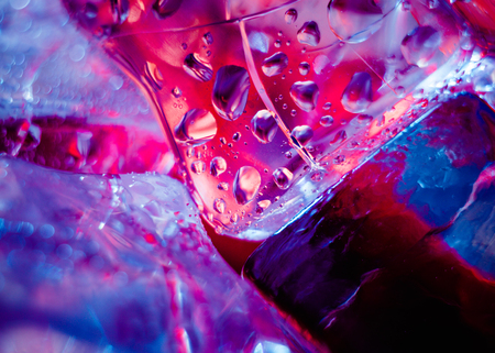 Ice cubes with drops  on a pink backgroundの写真素材