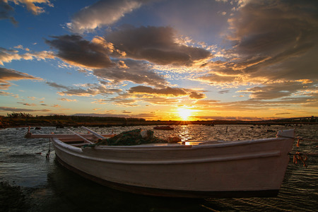 Boat in a small bay at sunsetの写真素材
