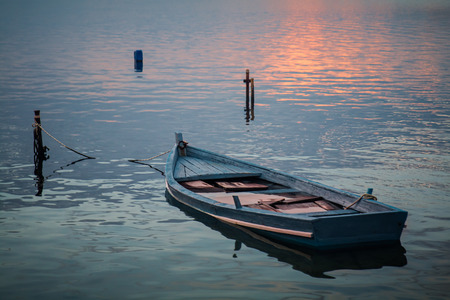Abandoned boat on beach  at sunsetの写真素材