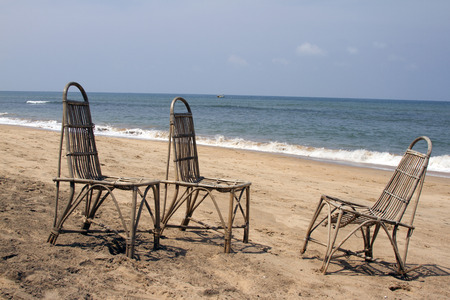 Three wattled chairs stand on a beach, wait for people against the sea. GOA India beach.の写真素材