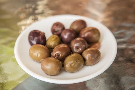 Ripe olives on a small plate. Snack bar.の写真素材