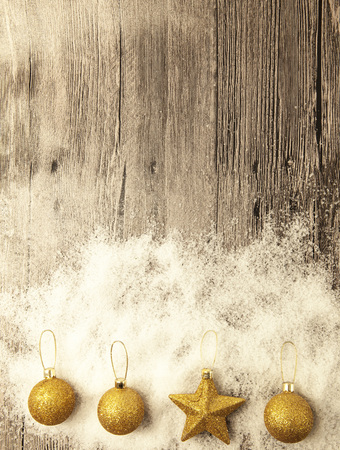 Glittering gold Christmas balls, snowballs, winter snow and star on wooden background.の写真素材
