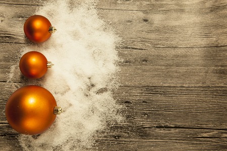 Christmas greeting card with Christmas balls and snow on a wooden backgroundの写真素材