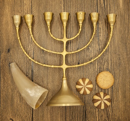 Hanukkah is the Jewish New Year. Candle with Christmas ornaments and cookies horn on wooden background.の写真素材