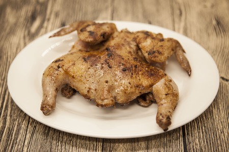 Fried chicken tapaka on porcelain plate with over wooden background.の写真素材