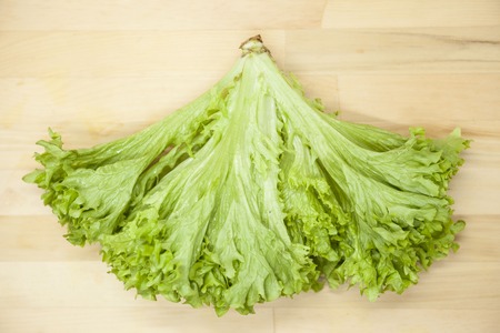 Green fresh bunch of a lettuce on a wooden background . The best healthy breakfast for the modern personの写真素材