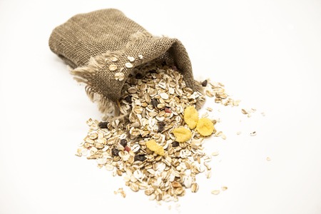Healthy eating oat flakes in a linen sack, closeup on a white background.の写真素材