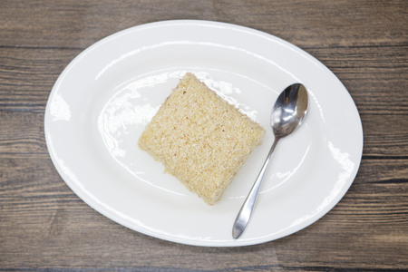 Dukan Diet. Fresh delicious diet cake at Dukan Diet on a porcelain plate with a spoon on a wooden backgroundの写真素材