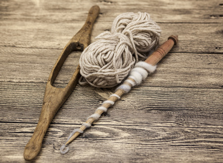 Two old wooden spindle with a ball of wool thread for the manufacture of woolen threads on a wooden...