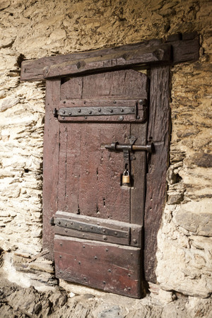 A large wooden door closed an old fortress in the stone wall of the castle in Germany on the Rhine River.の写真素材
