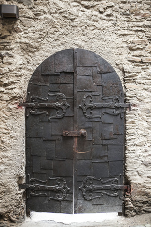 A large wooden door closed an old fortress in the stone wall of the castle in Germany on the Rhine River.の写真素材
