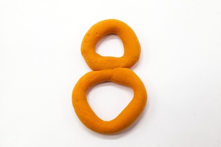 Orange  plasticine figure number eight 8 close-up on a white background. The icon for the Internetの写真素材