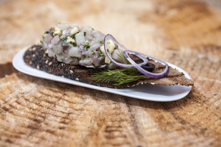 Fresh, delicious Spanish tapas with Tartar of herring and onions on a black baguette. An excellent background for the menus, cafe, restaurantの写真素材