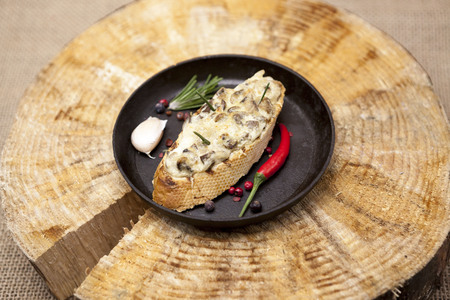 Home baked hot sandwich with mushrooms, cheese, onion on a cast-iron pan on a wooden backgroundの写真素材