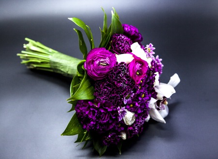 Beautiful bouquet of bride purple flowers on a dark backgroundの写真素材