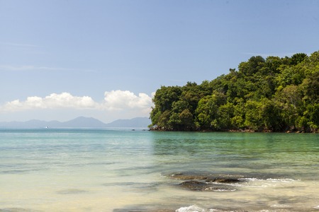 Beautiful beach with tropical trees with a wave of the sea and blue sky with white clouds. Thailand. Phuket.の写真素材