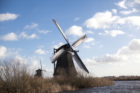 The old Dutch windmills, Holland, rural expanses . Windmills, the symbol of Holland. Holland windmill on a canal. Old mill chalk and flour . The beautiful backdrop of the countryside of Holland.Traditional dutch windmill near the canal. Netherlands. Old wの写真素材