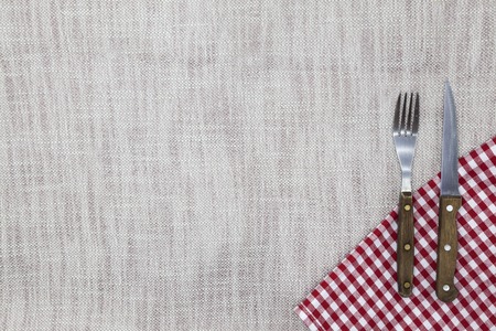 The background to create the restaurant's menu. Linen tablecloth fork knife on a bright checkered cloth. Is used to create a menu for the steak restaurantの写真素材