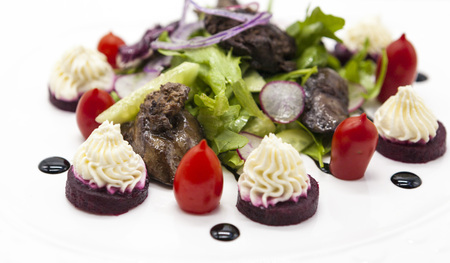 Hot chicken liver salad with lettuce on a plate closeup. Chicken liver with balsamic sauce salad, appetizer.の写真素材