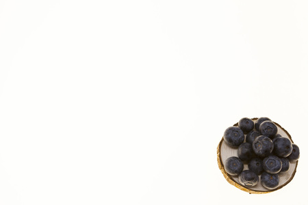 Blueberries on a wooden plate on a white background closeup.Background for confectionery, cafe fresh berries for pastryの写真素材