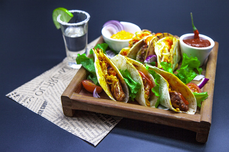 Tequila, Tacos and chili sauce. Mexican tortillas with a filling of hot meat. Close-up of tacosの写真素材