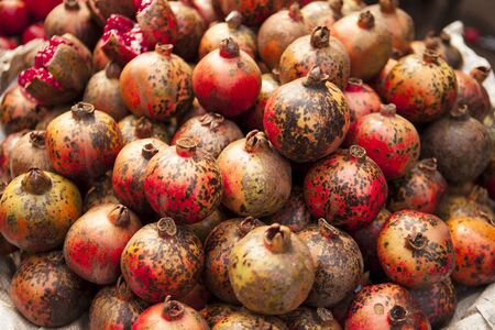 Fresh juicy pomegranates on a counter in the marketの写真素材