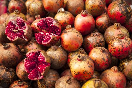 Fresh juicy pomegranates on a counter in the market.の写真素材