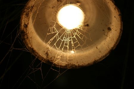 Spiderweb stretched across the barn light.の写真素材