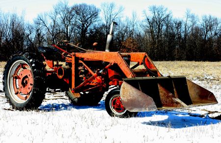 Old tractor sitting on the edge of a field.
