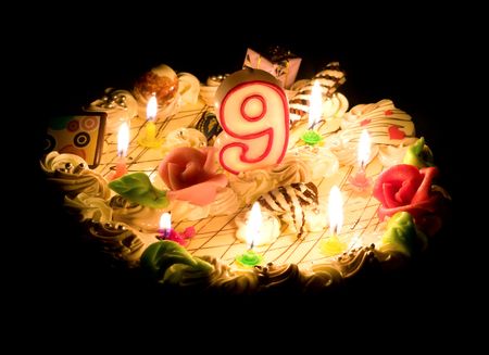 Birthday cake 9 years with candles in the darkの写真素材