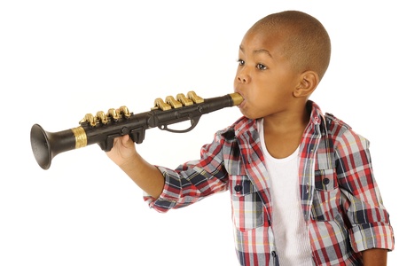 A handsome African American preschooler playing a black and gold clarinet   Isolated on white の写真素材