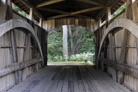 A view through an old covered bridge on a summer day の写真素材