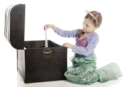 A beautiful young mermaid pulling a strand of large pearls from an old treasure chest.  On a white background.の写真素材