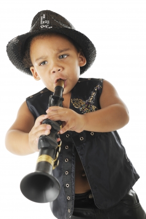 An adorable, intense preschool clarinetist in a sparkly fedora and black leather vest.  On a white background.の写真素材
