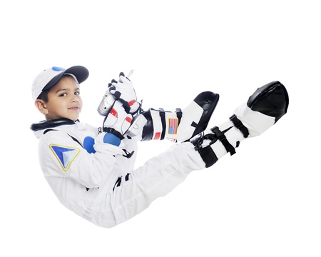 A happy elementary boy wearing an astronaut outfit including gloves and boots.  He's floating in space holding a silver drill as if to do a repair on his shuttle.  On a white background.の写真素材