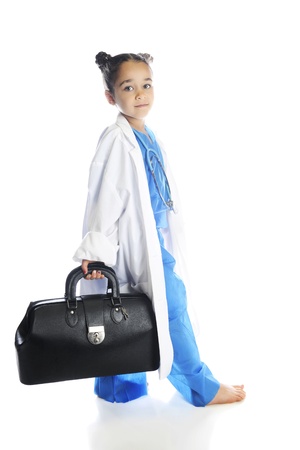 A young elementary "doctor" walking with her traveling doctor bag in hand.  On a white background.の写真素材