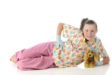 A pretty elementary "veterinarian" relaxed on the floor with an injured play puppy.  On a white background.の写真素材