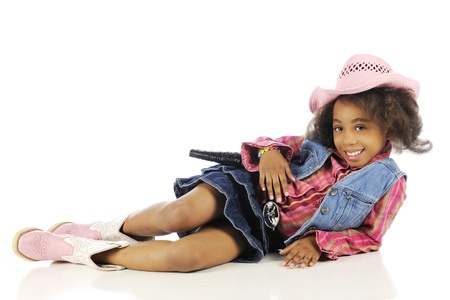 An elementary "cowgirl" smiling and relaxed on the floor.  On a white background.の写真素材