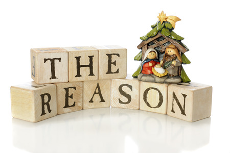 Rustic alphabet blocks arranged to say, "The Reason," with a small nativity scene (Mary, Joseph and Jesus only) to demonstrate that reason for the season.  On a white background. の写真素材
