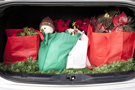 An opened car trunk filled with cloth bags full of gifts and decorations for Christmas.  の写真素材