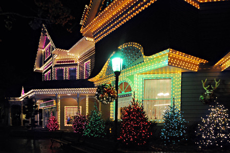 Nioght time image of a large, beautiful home all decked out in lights in celebration of Christmas.のeditorial素材