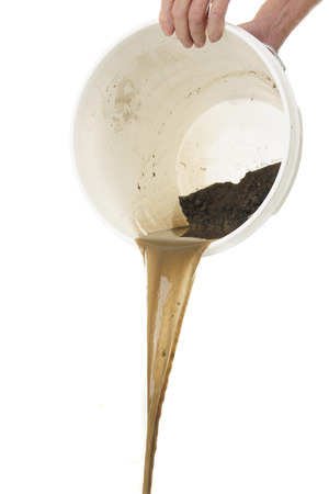 A senior man's hands holding a white bucket as he dumps out dirty water. On a white background.の写真素材