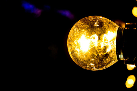A lightbulb shines in the dark nightの写真素材