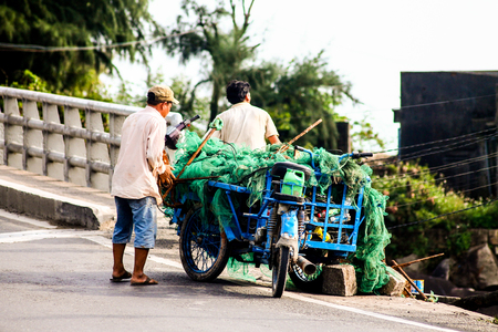 Two Vietnamese fishermen are transporting their netsのeditorial素材