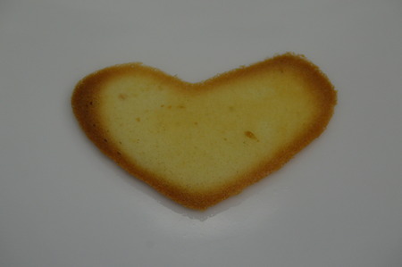 a baked hip-shaped waffle in heart shape on white backgroundの写真素材