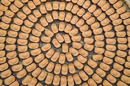 Chinese biscuits in the shape of old Chinese gold bars aranged in a circleの写真素材