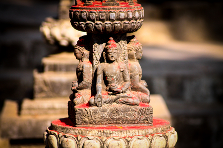 A Buddha statue with red powder coated in the Swaymabunath Temple in Kathmandu, Nepalの写真素材
